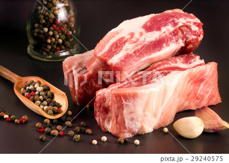 piece of pork on a dark background with peppercorn piece of pork on a dark background with peppercorn 29240575