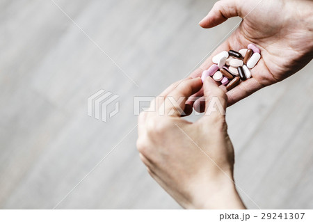 young addicted woman is deciding which pill of drug to eat young addicted woman is deciding which pill of drug to eat 29241307