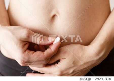 woman belly with pill in the hand 29241310