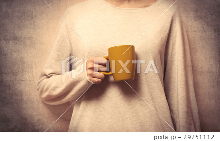 hand holding a yellow cup 29251112