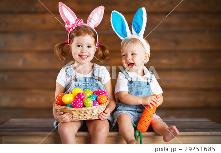 Happy kids boy and girl dressed as Easter bunnies with basket of 29251685