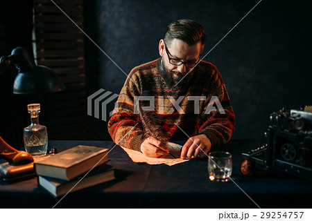Bearded writer in glasses writes with a feather Bearded writer in glasses writes with a feather 29254757