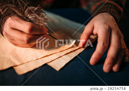 Male hands writes with a feather on vintage paper Male hands writes with a feather on vintage paper 29254758