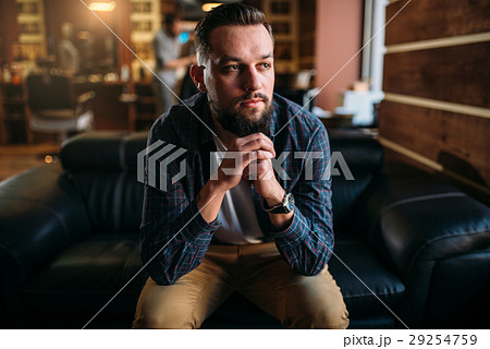 Bearded man sitting on a couch at the barbershop 29254759