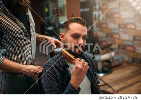 Male client combing his beard at the barbershop Male client combing his beard at the barbershop 29254778