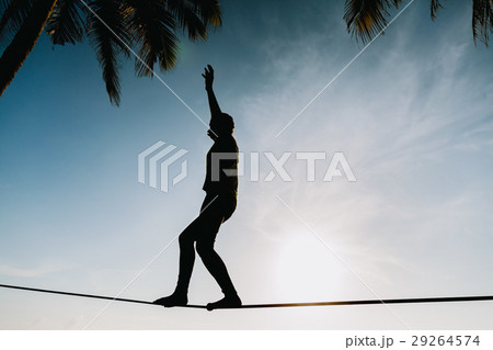teenage girl balancing on slackline with sky view teenage girl balancing on slackline with sky view 29264574
