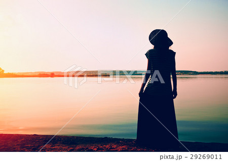 silhouette woman standing alone at sea coast 29269011