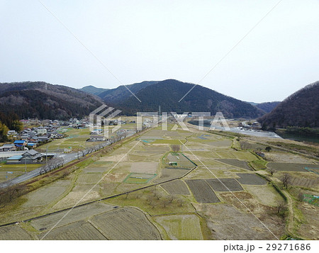 ドローン空撮 田舎の田んぼと背景の山の写真素材