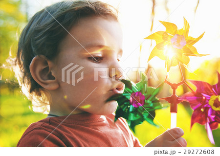 cute boy blowing wind wheel in sunshine 29272608