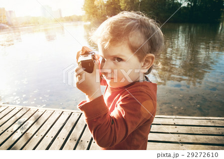 smiling cute boy taking picture with retro camera 29272610