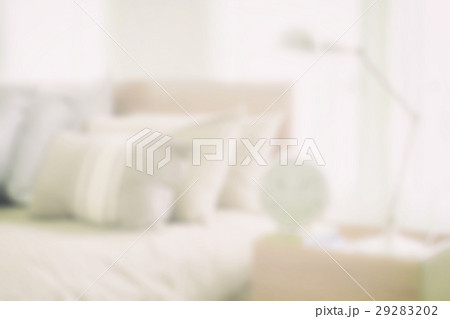 blurred bedroom with reading lamp and alarm clock 29283202