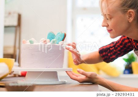 Woman decorates homemade cake. Culinary business. 29293431