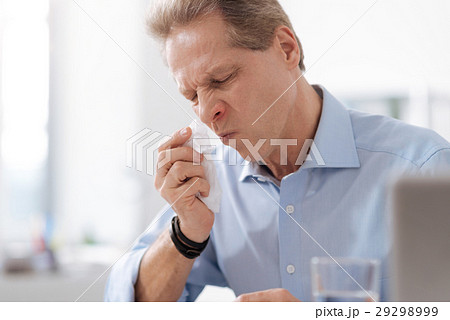 Disturbed male person while wiping his nose 29298999