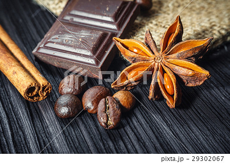 Chocolate bar and spices on wooden table, close up 29302067