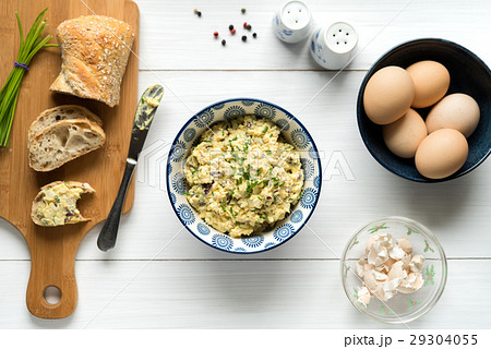 Egg salad in bowl topped with chive on white table Egg salad in bowl topped with chive on white table 29304055