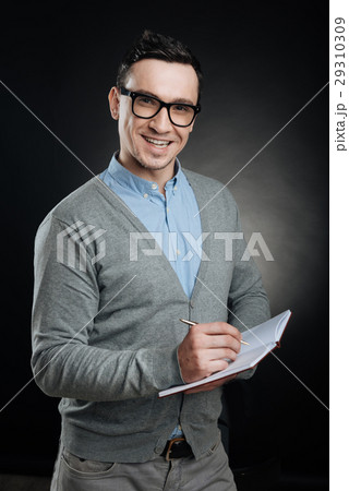 Positive delighted man holding notebook in left Positive delighted man holding notebook in left 29310309