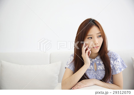 Asian young woman calling talking on phone callephohe in coffeeshop Asian young woman calling talking on phone callephohe in coffeeshop 29312070