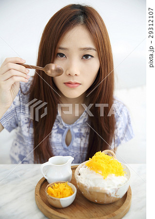 Asian young woman eating Shaved ice with milk and coconut 29312107