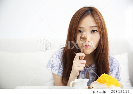 Asian young woman eating Shaved ice with milk and coconut 29312112
