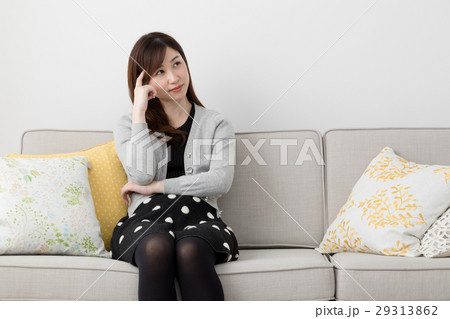 顎に手を当てる女性 考えるの写真素材
