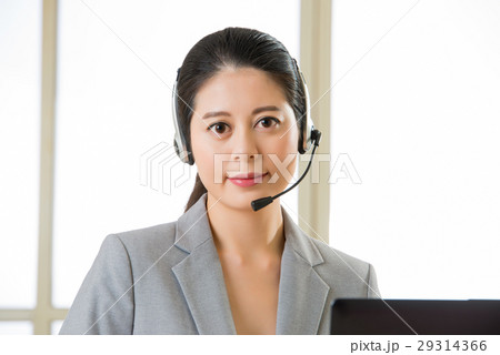 Smiling Asian woman with a headphone and working Smiling Asian woman with a headphone and working 29314366
