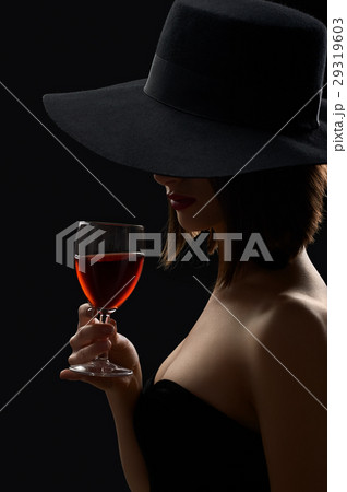 Elegant mysterious woman in a hat holding a glass Elegant mysterious woman in a hat holding a glass 29319603