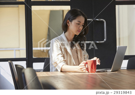 The woman is focusing on the screen seriouly and thinking about something 29319843