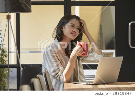 The woman is thinking of an idea with a cup of coffee in her hand 29319847