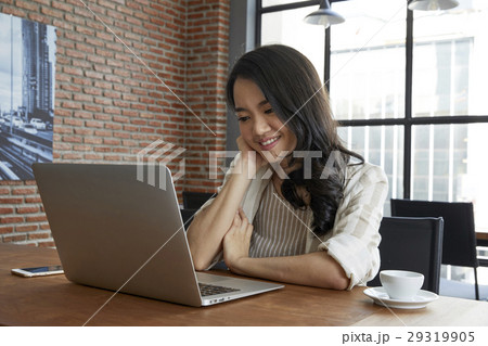 Young lady is working with her laptop and seems satisfied with it.  29319905