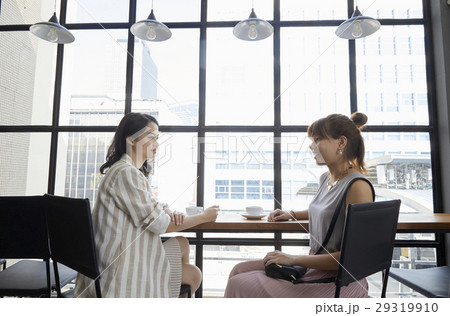 Two office ladies are drinking coffee and talking 29319910