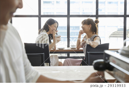 Two young ladies are talking and laughing very happily Two young ladies are talking and laughing very happily 29319933