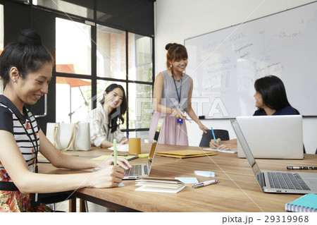 The female colleagues are discussing new strategy in office. The female colleagues are discussing new strategy in office. 29319968