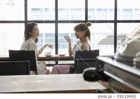 Portrait of two smiling beautiful women having a cup of coffee in café. 29319992