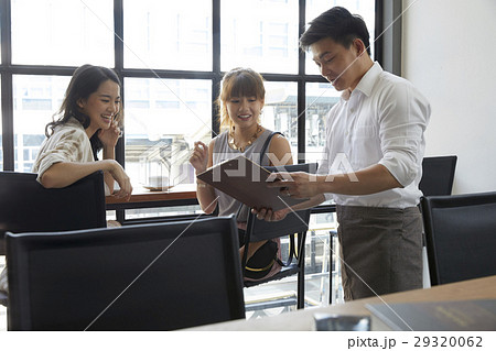 A group of people is discussing about work in office. 29320062