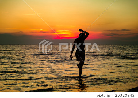 Silhouette of a sensual woman at sunrise on the 29320545