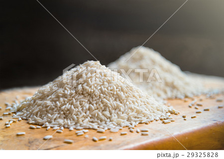 Two piles of white rice on wooden table background Two piles of white rice on wooden table background 29325828