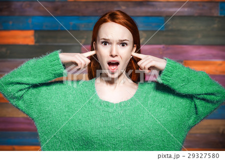 woman covering her ears with your fingers and woman covering her ears with your fingers and 29327580