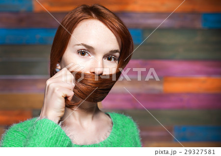 young beautiful red-haired girl covering mouth young beautiful red-haired girl covering mouth 29327581