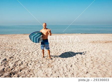 Surfer is going to surf in the ocean in a sunny 29336603