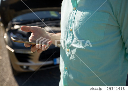 close up of man with smartphone and broken car close up of man with smartphone and broken car 29341418