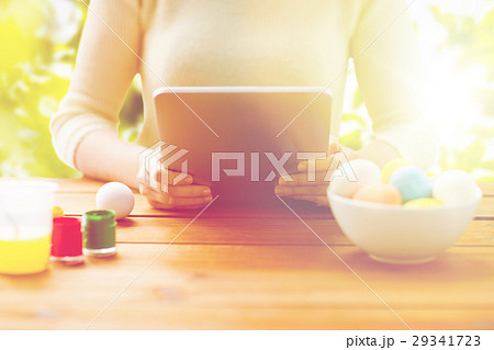close up of woman with tablet pc and easter eggs close up of woman with tablet pc and easter eggs 29341723
