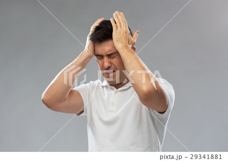 unhappy man suffering from head ache 29341881