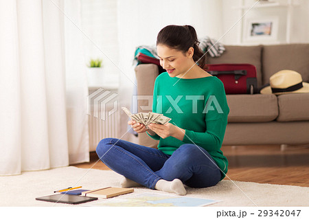 happy woman with money and travel map at home 29342047