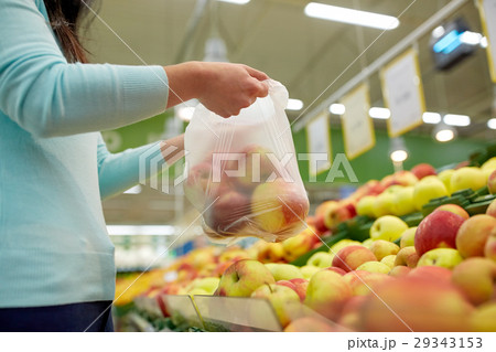 woman with bag buying apples at grocery store woman with bag buying apples at grocery store 29343153