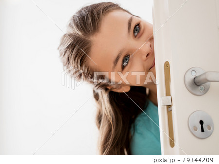 happy smiling beautiful girl behind door at home happy smiling beautiful girl behind door at home 29344209