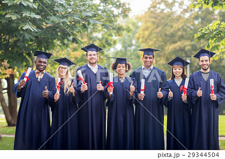 happy students with diplomas showing thumbs up happy students with diplomas showing thumbs up 29344504