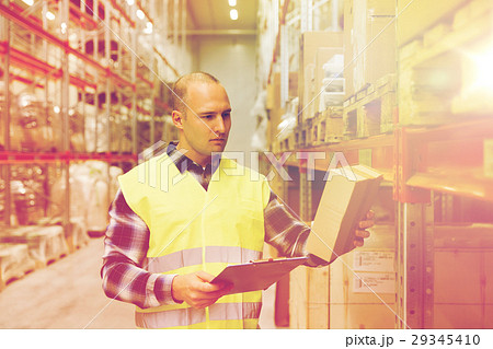 man with clipboard in safety vest at warehouse 29345410