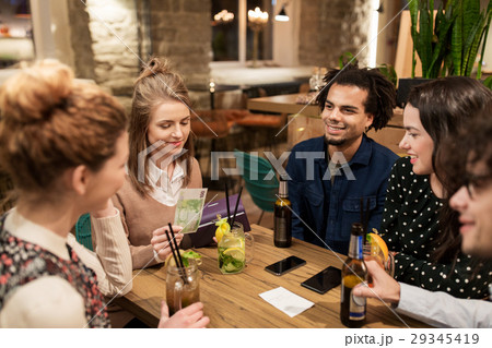 friends with drinks, money and bill at bar 29345419