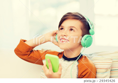 happy boy with smartphone and headphones at home happy boy with smartphone and headphones at home 29345426
