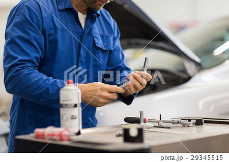 mechanic man with wrench repairing car at workshop mechanic man with wrench repairing car at workshop 29345515